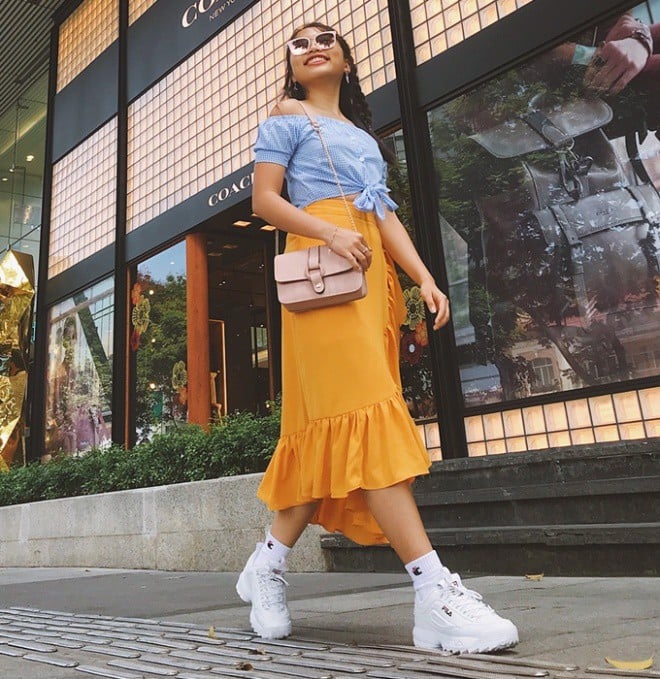 Cô bé Phương Mỹ Chi trong thật ra dáng khi phối đồ với giày FILA cùng chiếc áo croptop và chân váy midi màu vàng cam