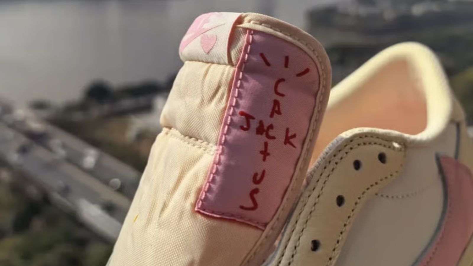 Hinh anh 3: Travis Scott x Air Jordan 1 Low 'Shy Pink' voi mau hong pastel va thiet ke Reverse Swoosh.